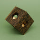 Auf eine Ecke gekippter Holzwürfel mit sichtbaren Kugeln in den Öffnungen – dekorative Puzzlebox zum Knobeln.