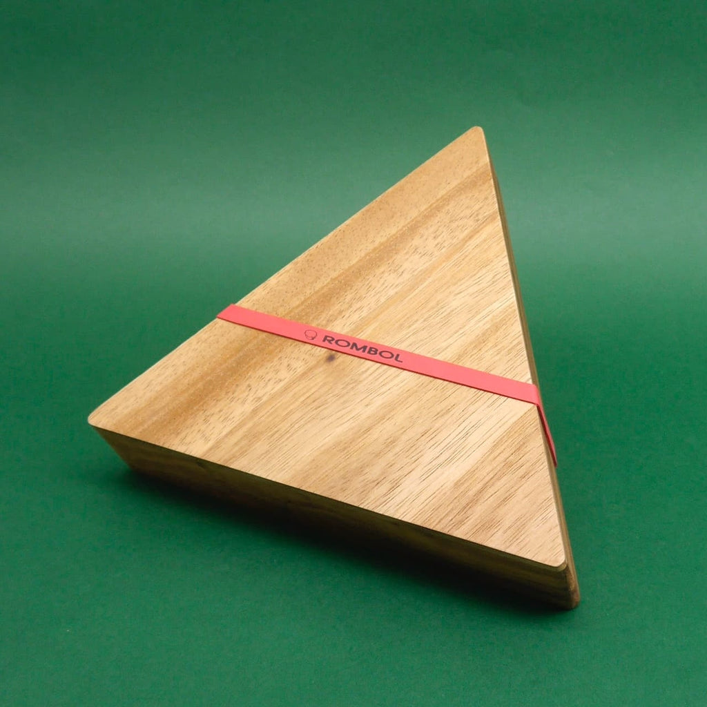 Dreieckige Holzbox mit dem Logo "Rombol" auf grünem Hintergrund – das Holzspiel ist vollständig geschlossen.