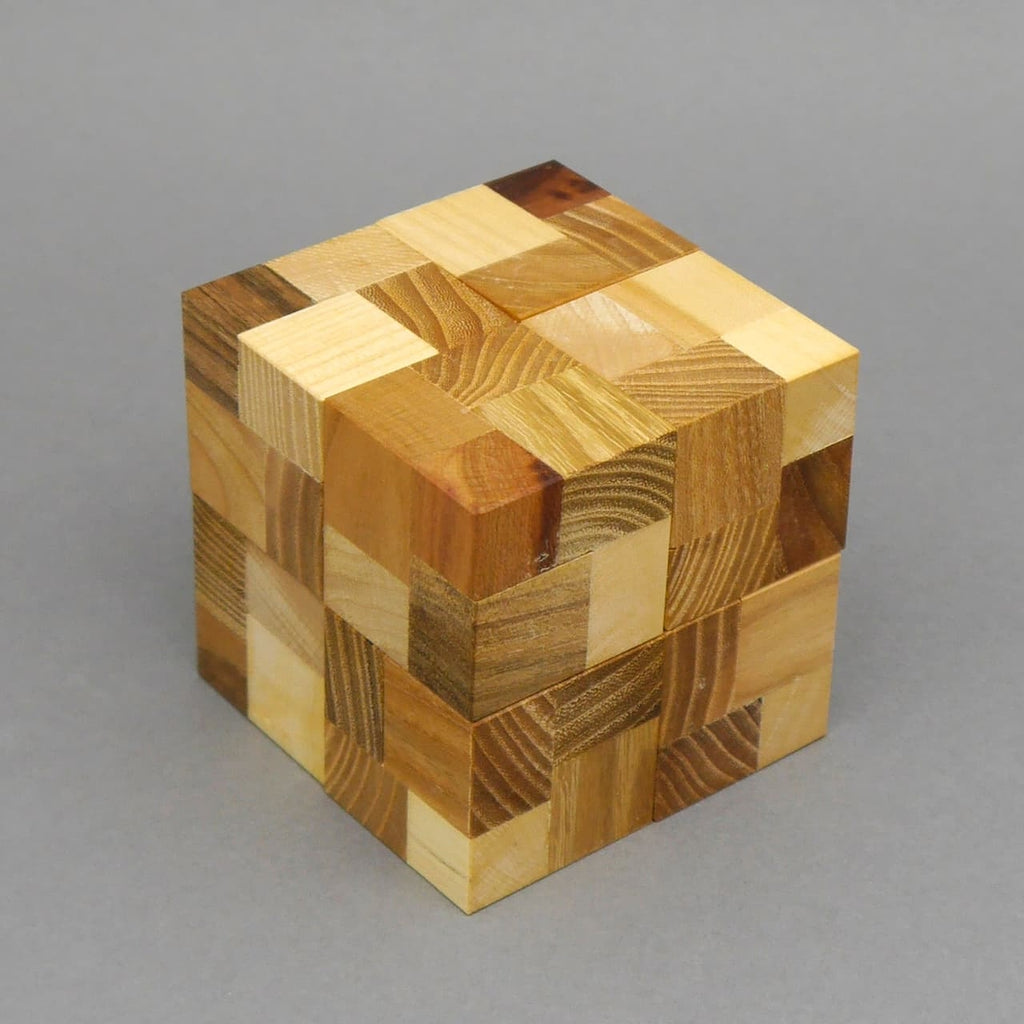 Fertig zusammengesetzter Trimaj Cube 3H als mehrfarbiger Logikwürfel aus Holz, aufgenommen vor grauem Hintergrund.