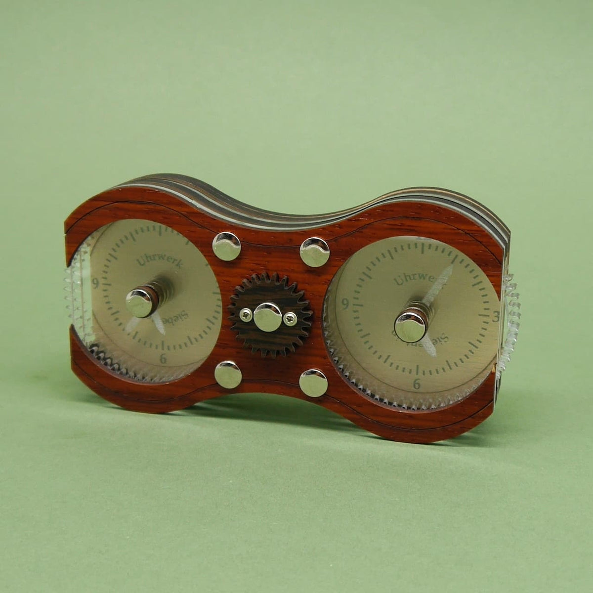 Geduldsspiel aus Holz in Form eines Uhrwerks, bei dem zwei Zifferblätter durch Drehmechanismus verbunden sind.
