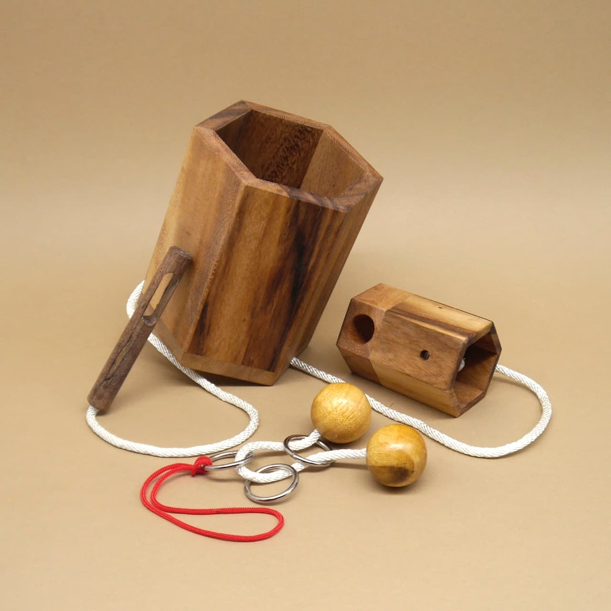 Zerlegter Flaschensafe aus Holz mit Kordel, Ringen und Holzkugeln; Teile der Geschenkverpackung für eine Weinflasche.