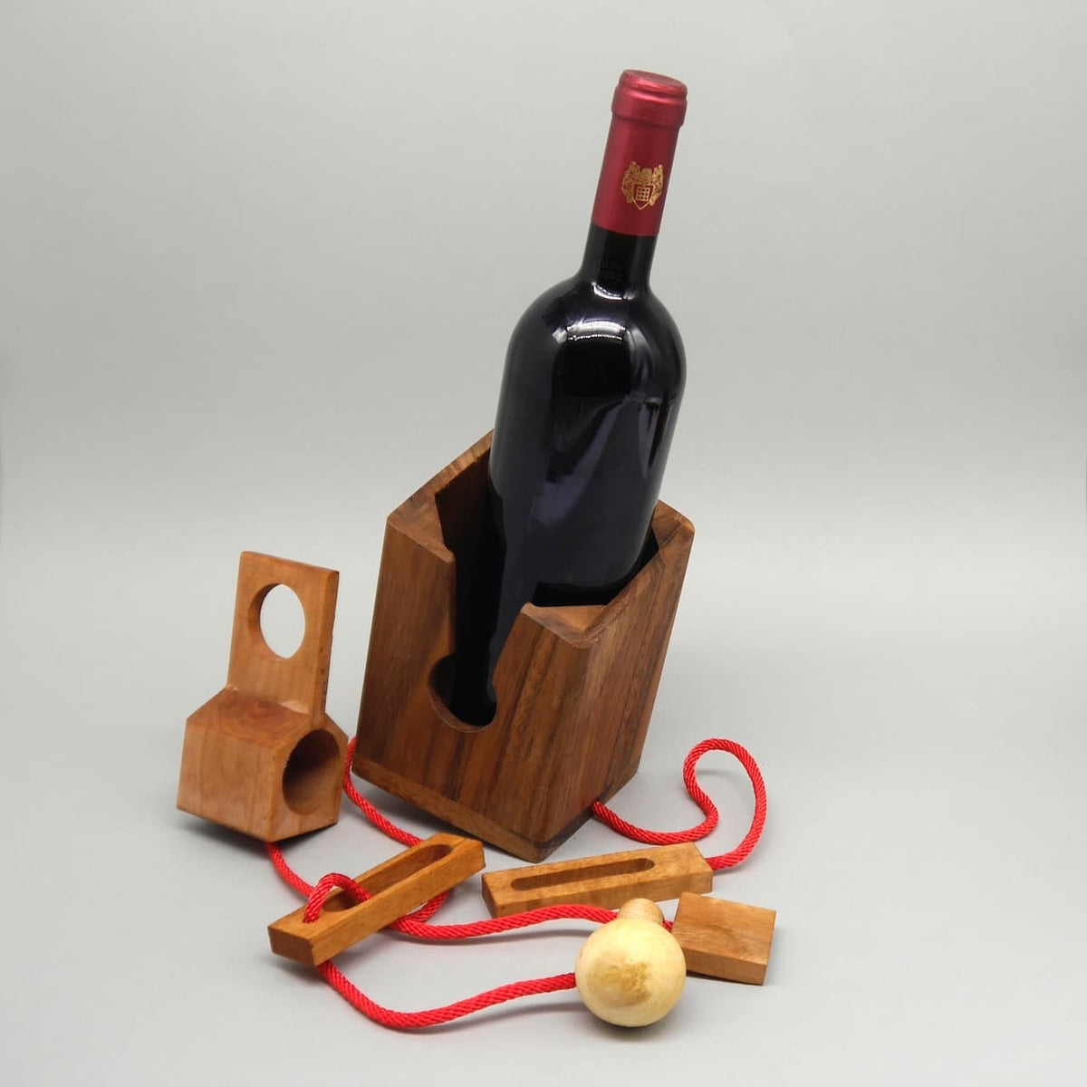 Weinverpackung als Holzpuzzle: Geduldsspiel mit roter Schnur und Holzkugeln – Geschenk zum Geburtstag.