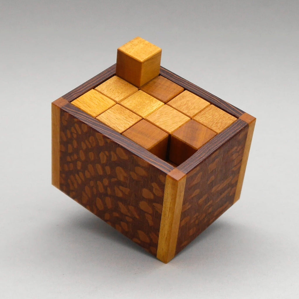 Gefüllte Yoga Knobelbox als Denkspiel, Holzwürfel sind ordentlich eingelegt, ein Teil ragt oben aus der Box.