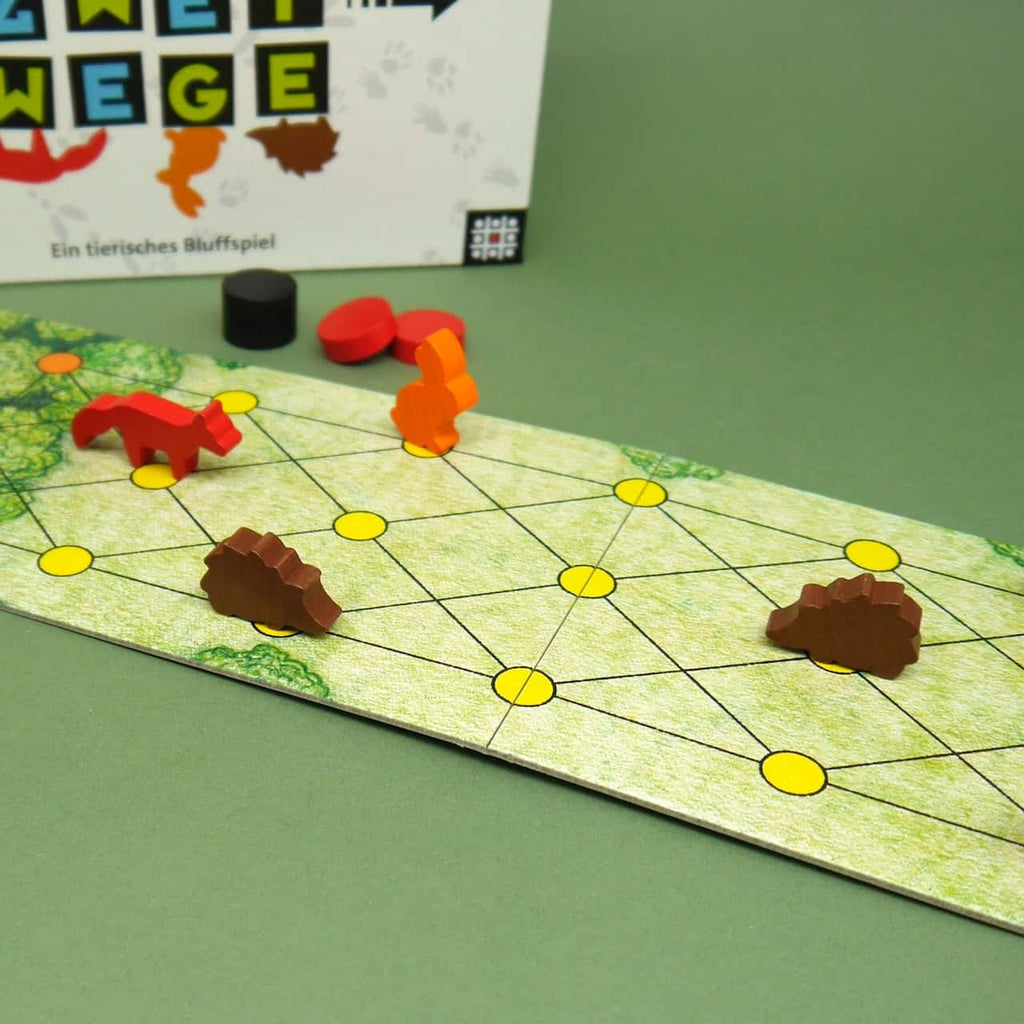 Holzfiguren von Fuchs, Hase und Igel stehen auf einem schmalen Spielbrett mit gelben Punkten eines 2-Personen-Spiels.