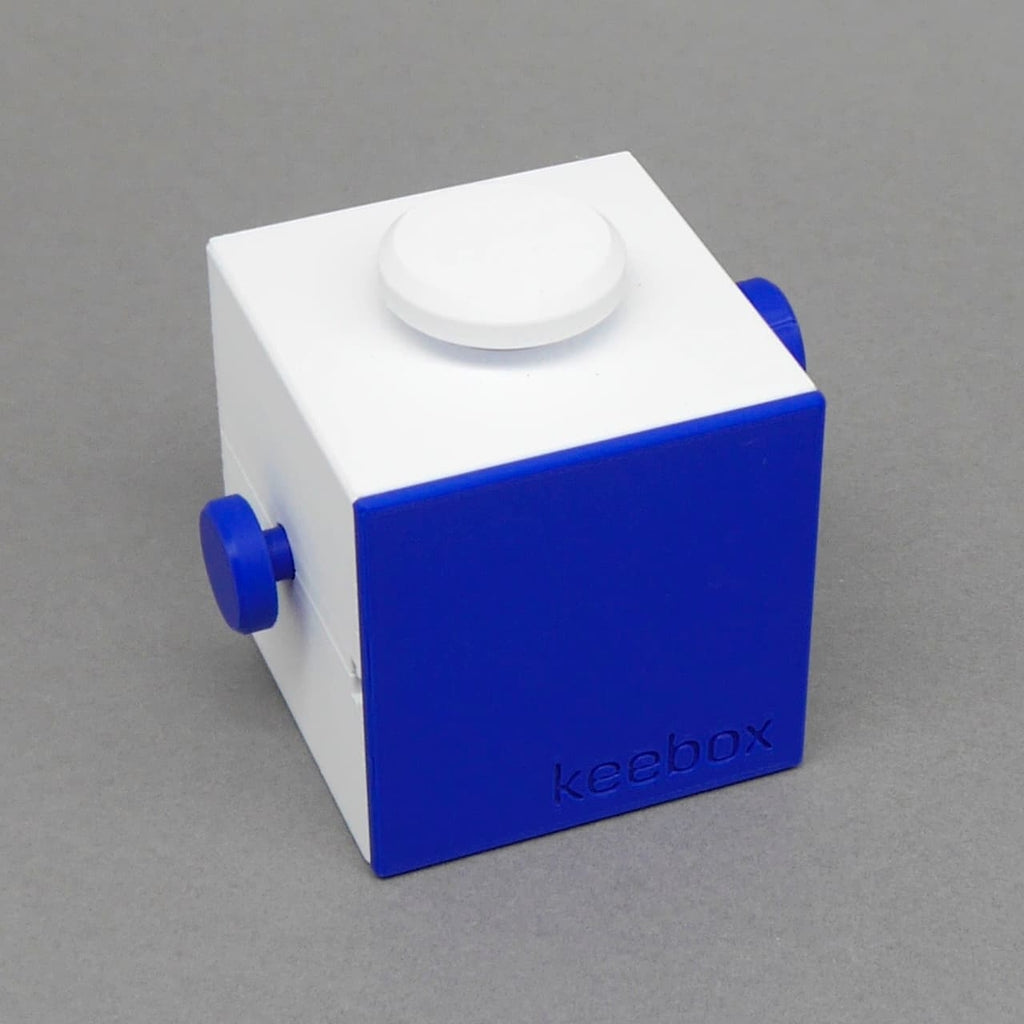 Keebox blue Brainteaser: blau-weiße Knobelbox als Würfel mit Drehknöpfen, schräg freigestellt.