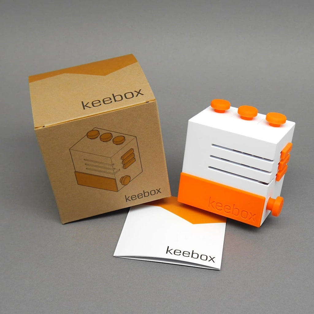 Keebox Set mit Anleitung und Karton; orange-weiße Box als Logikspiel/Brainteaser.