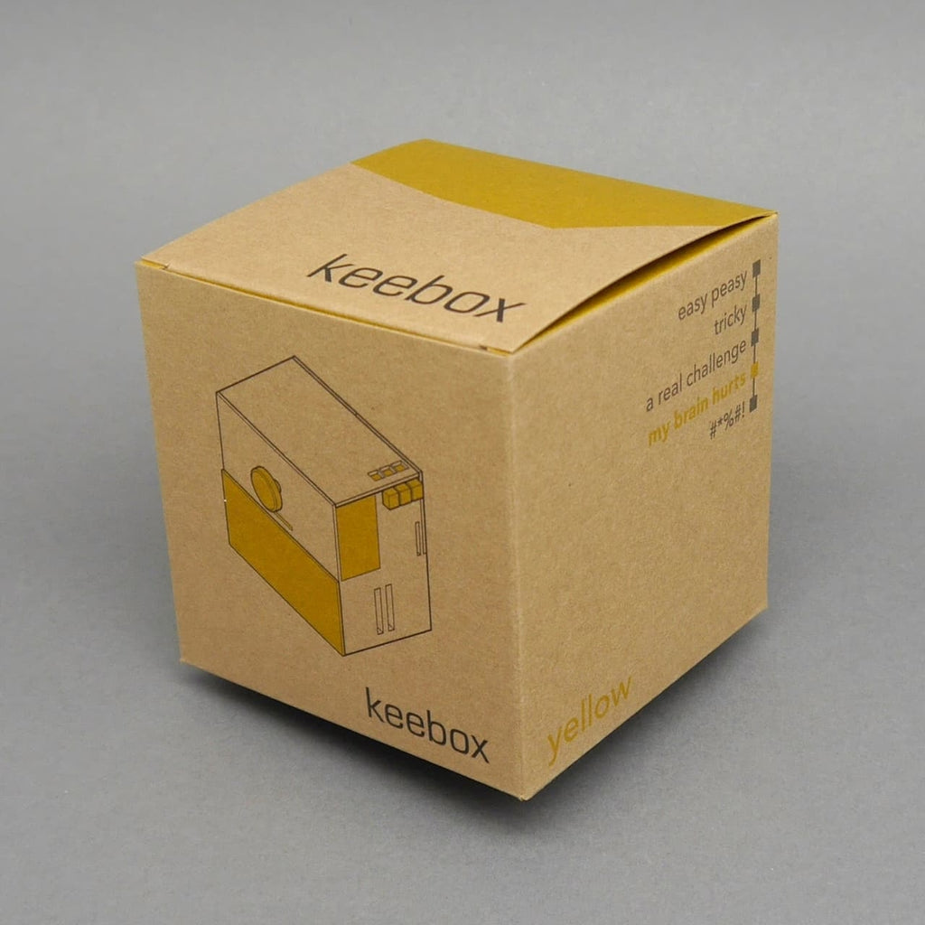 Kartonverpackung ‚keebox yellow‘ der Knobelbox mit gezeichneter Produktansicht.