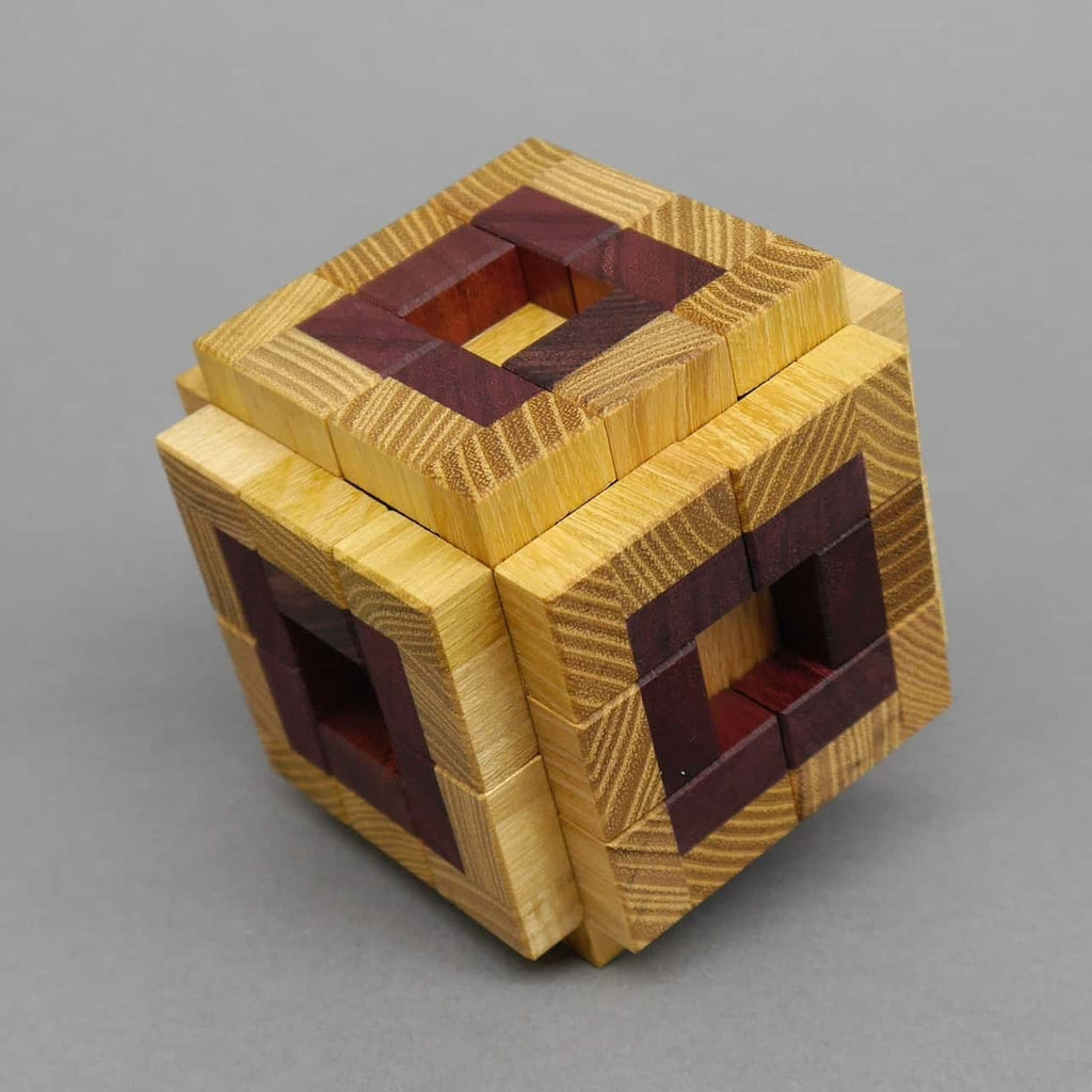Holzwürfel-Puzzle, das aus mehreren passgenauen Teilen besteht und sorgfältiges Tüfteln erfordert.